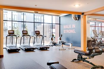 a fitness room with treadmills and other exercise equipment